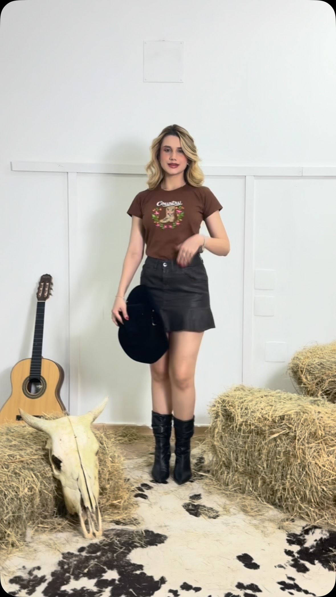 Look country com T-shirt marrom, saia preta e botas